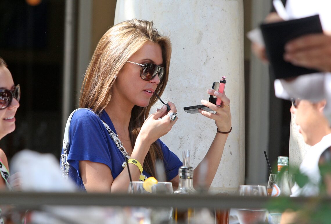 Audrina Patridge reapplies her lip gloss during lunch with her mother at the Grove in L.A.