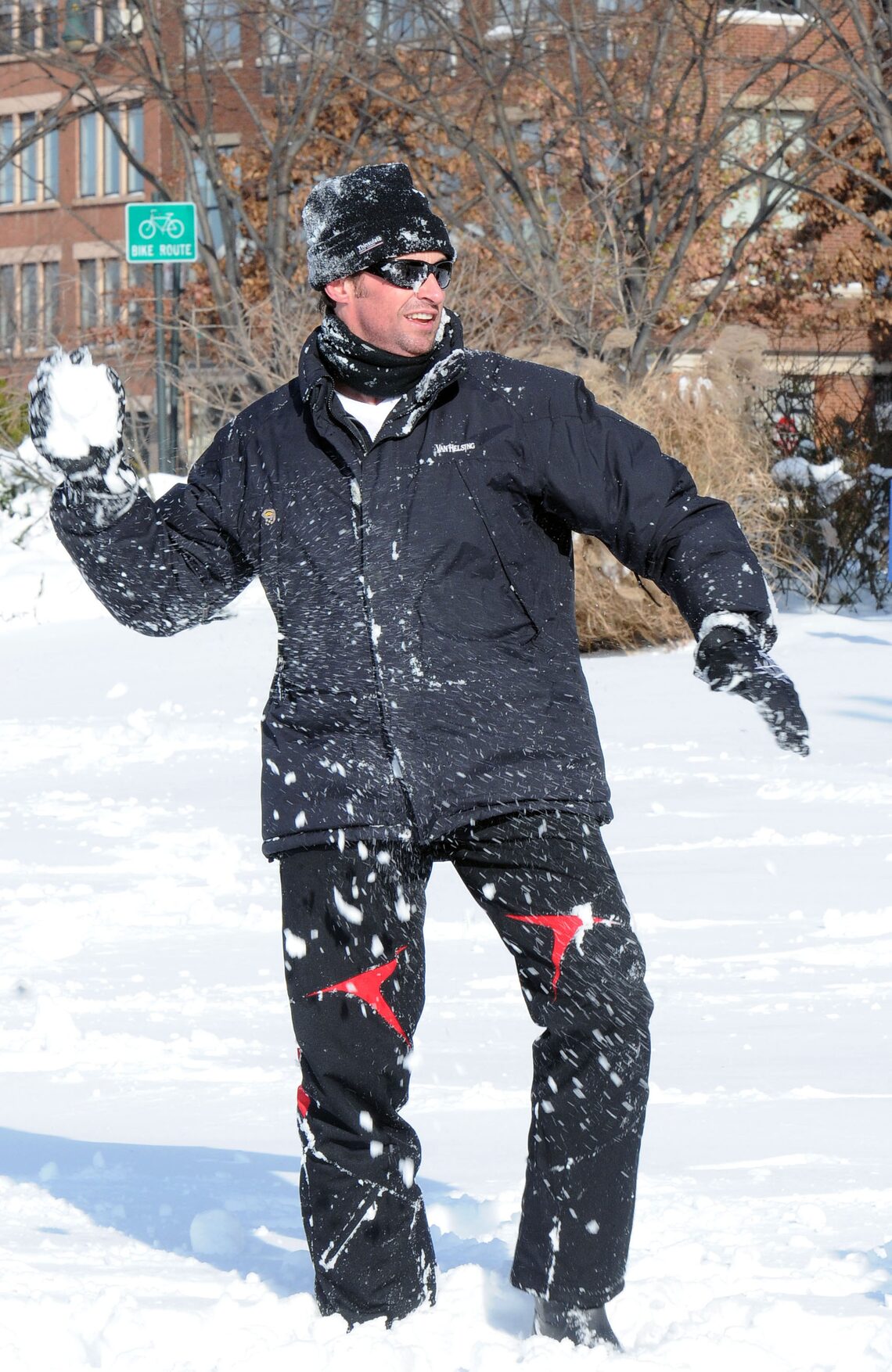 Hugh Jackman prepares to launch a snowball during a wintery battle with his children in NYC.