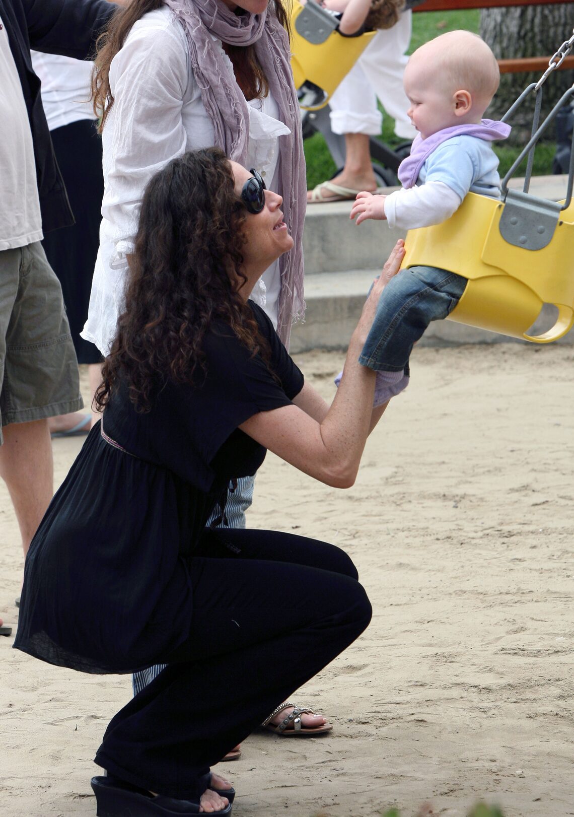 Minnie Driver laughs as she pushes adorable son Henry on the swings at a park in Malibu.