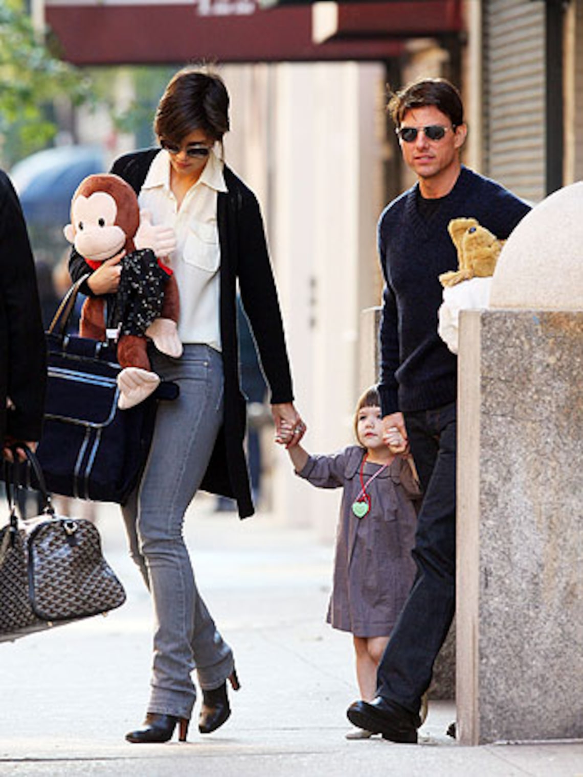 Katie Holmes, Tom Cruise and daughter Suri tote a Curios George while cruising out of their Big Apple home today. (Photo Credit: INFDaily)