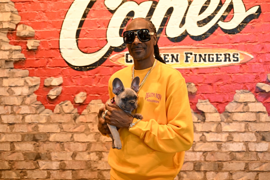 Snoop Dogg and his new puppy Baby Boy Broadus posed during a surprise “shift” at Raising Cane's in Las Vegas ahead of National Chicken Finger Day.