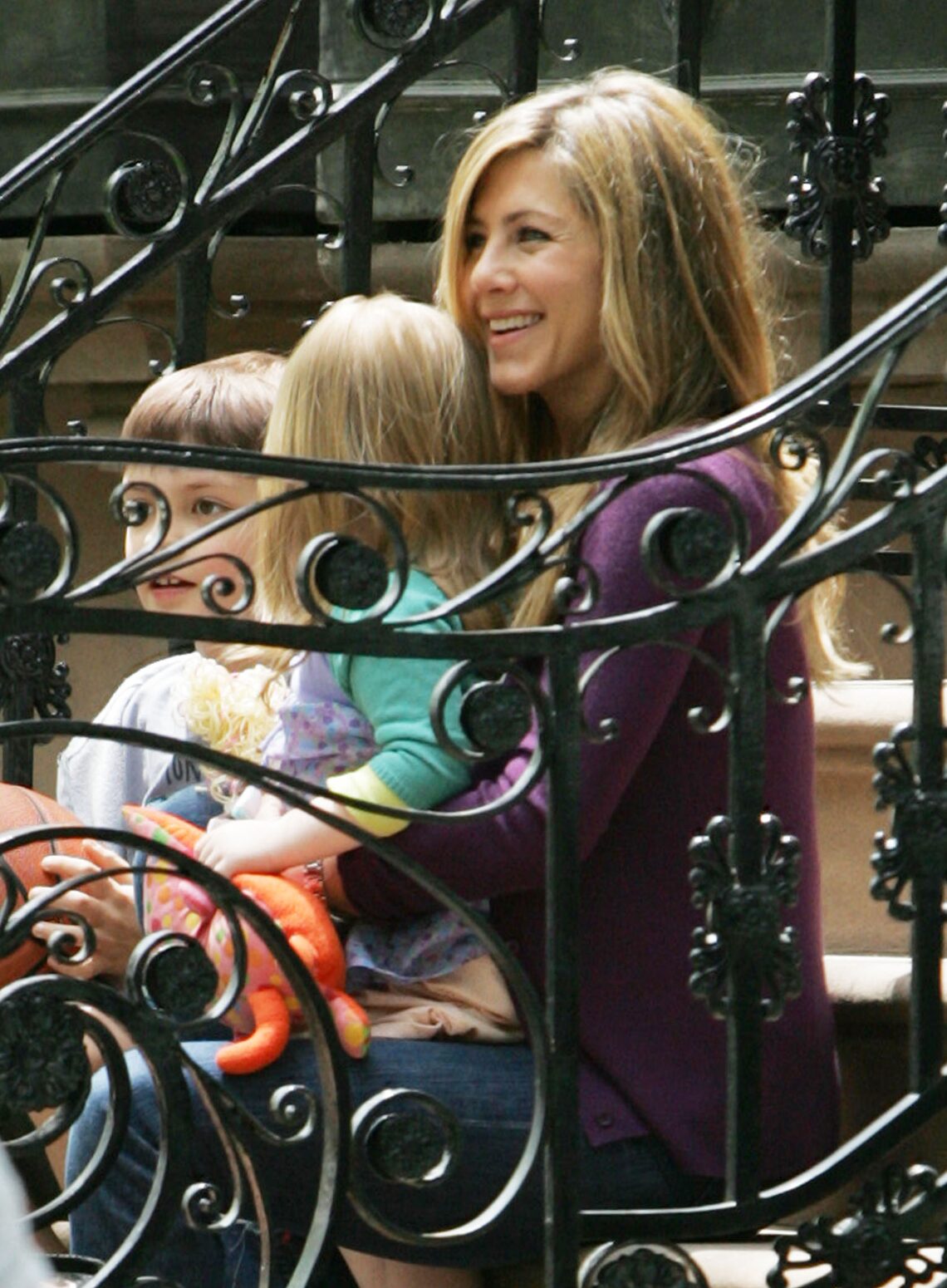 A beaming Jennifer Aniston holds tight to an adorable tot on the set of "The Baster" in Brooklyn.